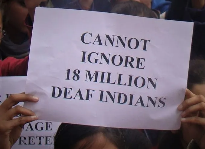 A protestor holding a poster which reads - Cannot ignore 18 million deaf Indians