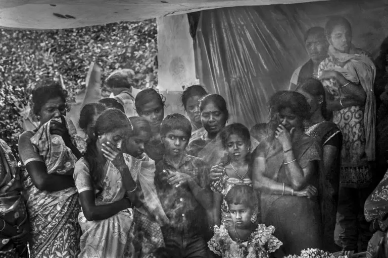 मुदुमलाई टाइगर रिजर्व के पास गुडलुर के पट्टावायल गांव में चाय बागान में काम करने के दौरान बाघ द्वारा मारी गई 38 वर्षीय महिला की मौत पर शोक व्यक्त करते पड़ोसी। तस्वीर- सेंथिल कुमारन।