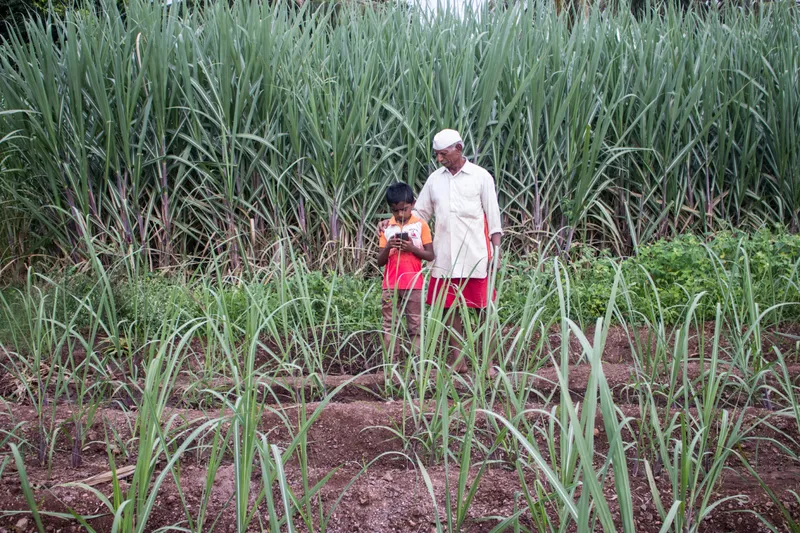 नारायण अपने नौ वर्षीय पोते वरद के साथ, जिन्होंने 2020 में जैविक खेती के बारे में जानकारी हासिल करने के लिए यूट्यूब का रुख किया, क्योंकि रासायनिक उर्वरकों के चलते उनके दादा-दादी के संकट बढ़ते जा रहे थे. तस्वीर- संकेत जैन/मोंगाबे