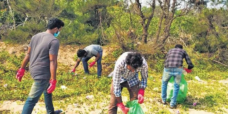 समुद्र तट की सफाई करते युवा (फोटो साभार: द न्यू इंडियन एक्सप्रेस)