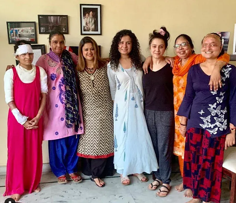 तानिया और रिया शर्मा पुनर्वसन केंद्र में एक समूह चिकित्सा सत्र के बाद सर्वाइवर्स के साथ