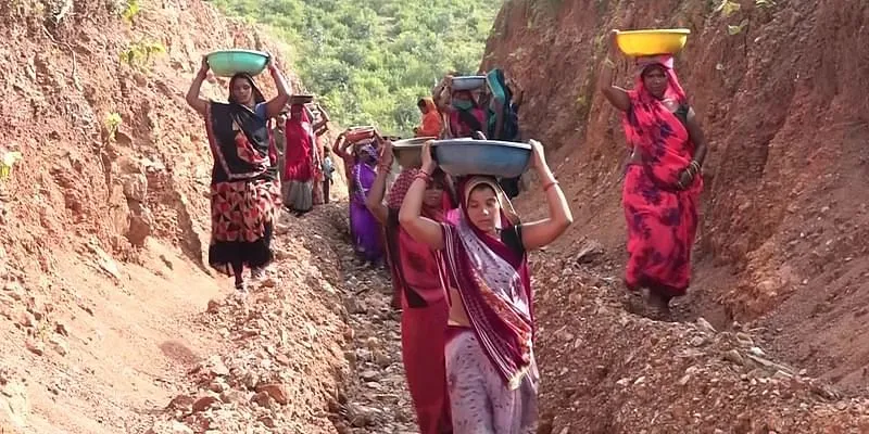 अंगरोटा की महिलाएं गाँव में तालाब में पानी मोड़ने के लिए एक पहाड़ी को काट रही हैं। (चित्र: ANI/Twitter)