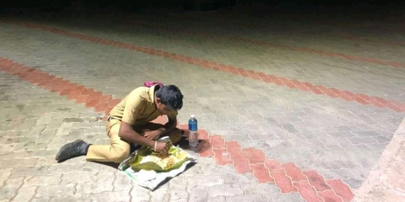 लॉकडाउन के बीच जमीन पर बैठकर खाना खाते पुलिसकर्मी की तस्वीर वायरल, फिल्म निर्देशक ने ट्विटर पर किया शेयर 