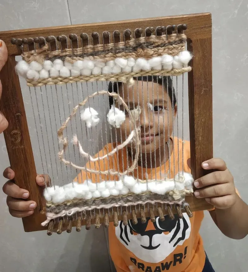 A child with a portable loom frame