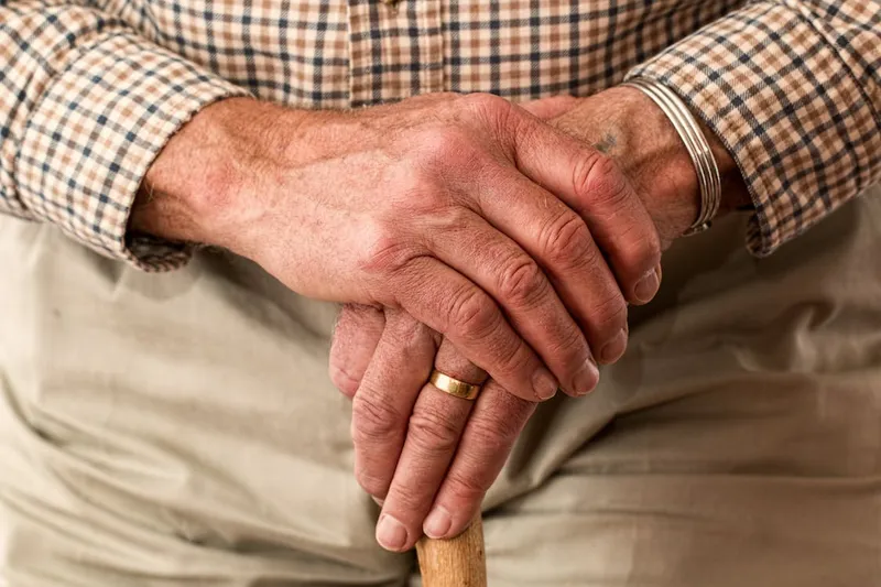 hands walking stick elderly person