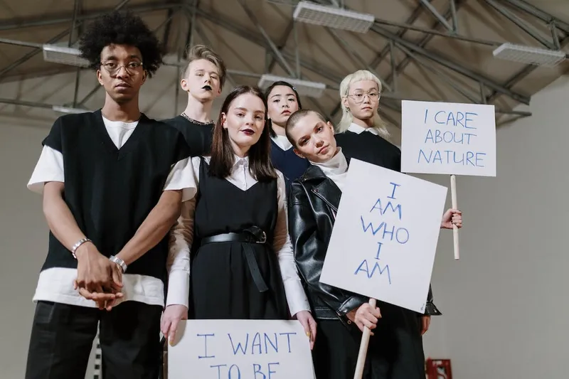 3 GenZs holding placards of self-expression and identity