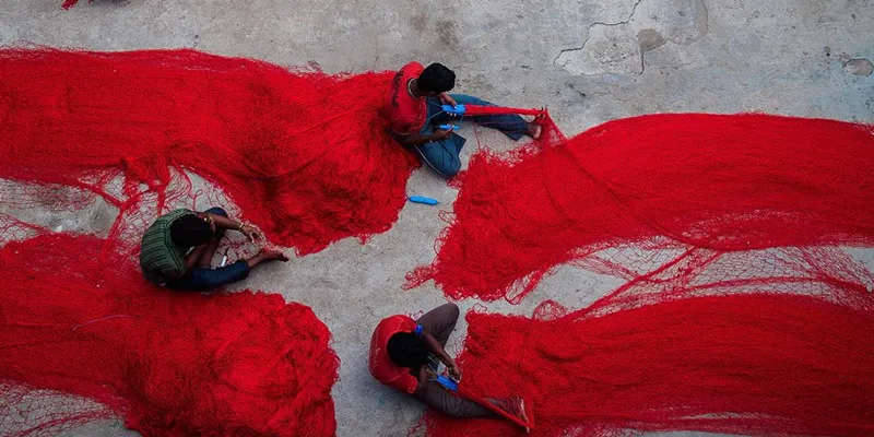 Workers untangle red nets in Chennai. (Image: Unsplash)