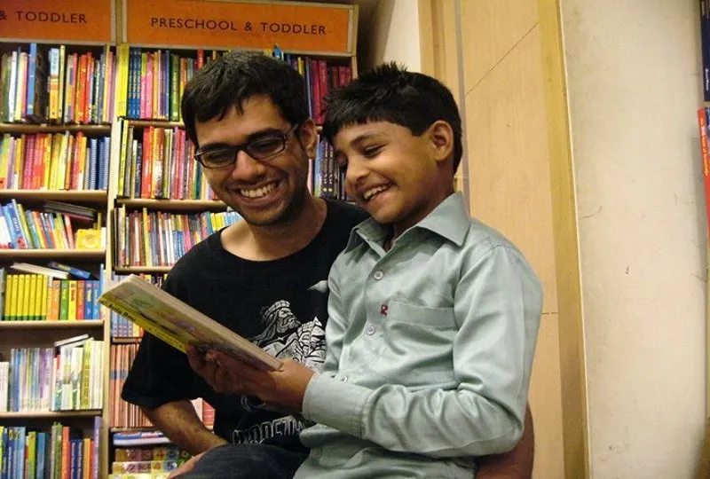 Anoop(left) helping a student discover the joy of reading