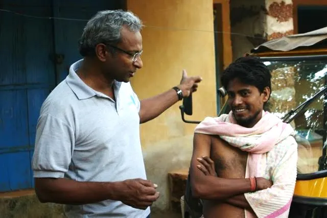 Jacob Mathew speaking to a villager on the benefits of safe water