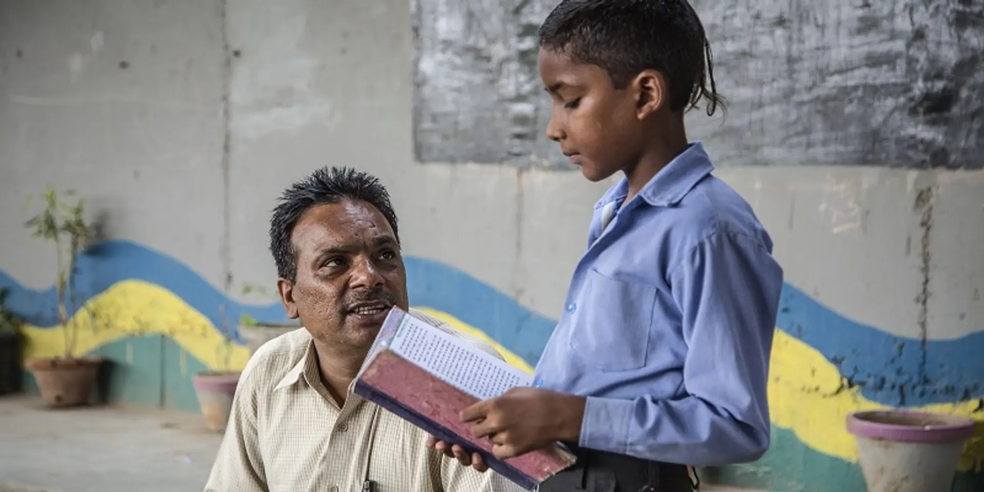 This shopkeeper runs a school for slum children under a railway bridge