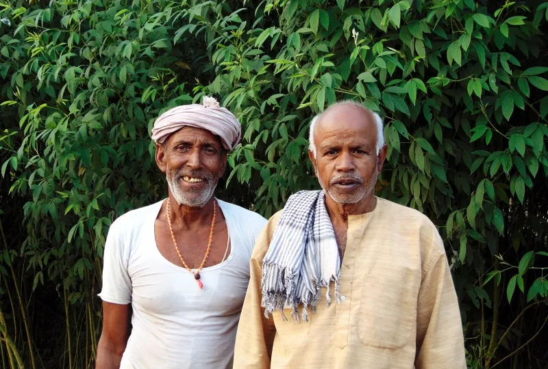 Farmers posing in fornt of their green fields