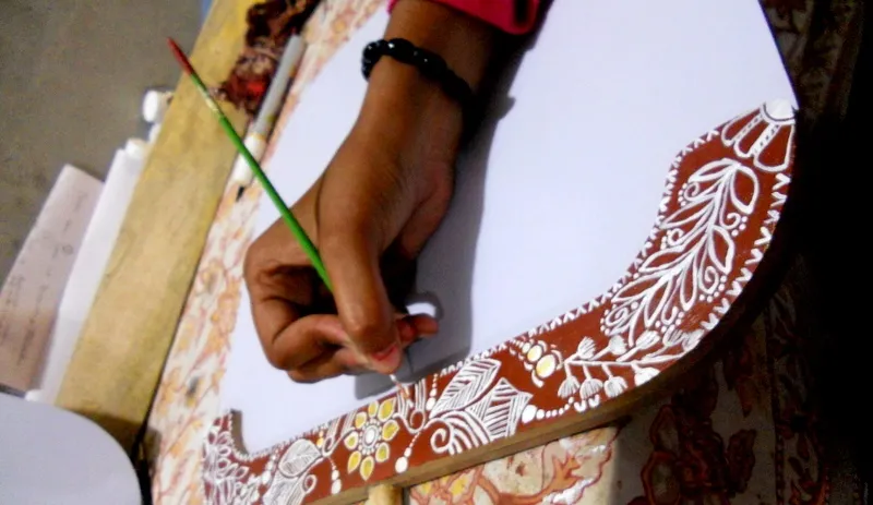 A woman from IVEI using her mehendi skills on a white board