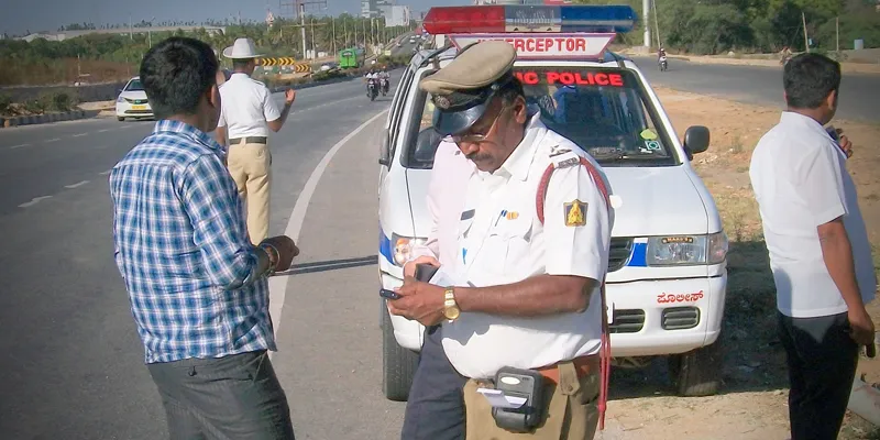 A Bengaluru traffic police officer generates a challan for the violator. He will soon carry a hand-held PoS machine to enable card payments
