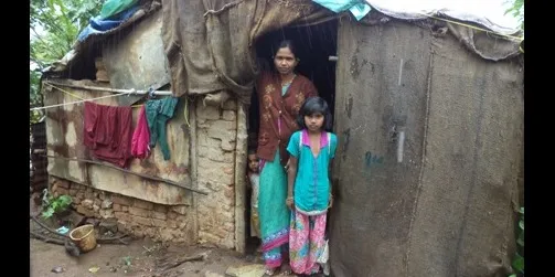 Sakshi with her mother in front of their hut